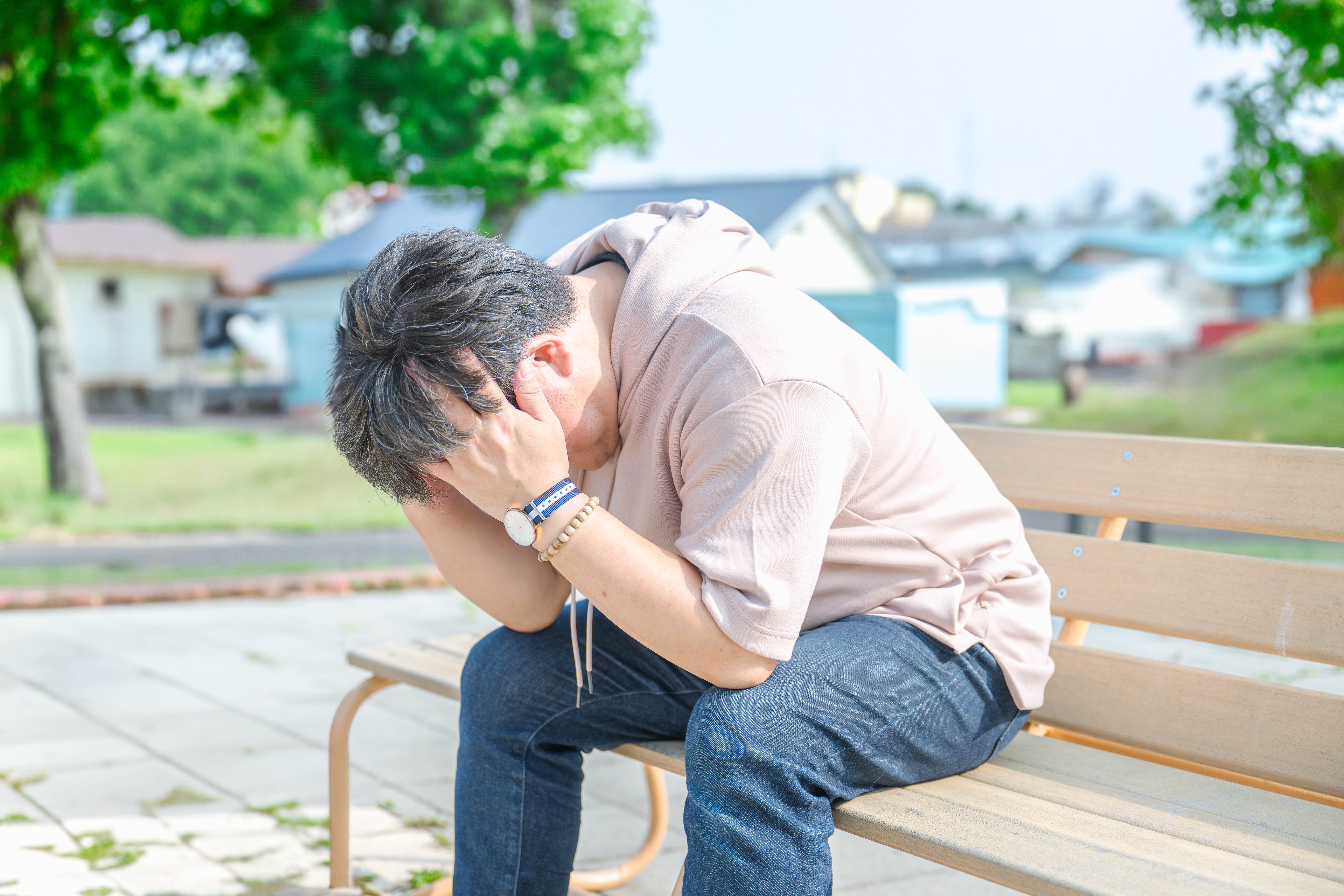 ベンチで落ちこむ男性